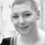 portrait of a smiling woman with a shaved head